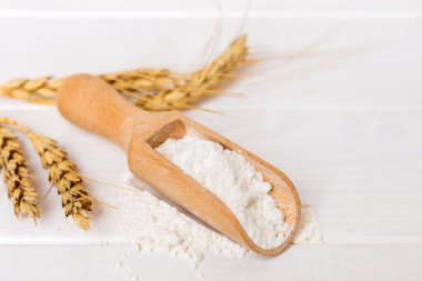 Tahta kasede buğday unu ve renkli arka planda buğday dikenleri. dünya buğday krizi.