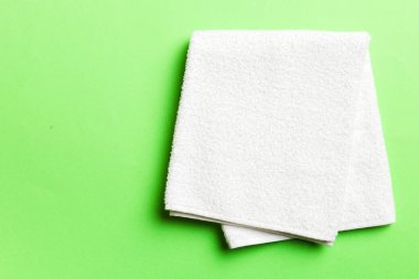 Renkli arkaplanda kopyalama alanı olan beyaz havluların üst görünümü.