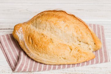 Kırsal masa manzaralı peçeteli taze pişmiş ekmek. Sağlıklı beyaz ekmek izole edilmiş..