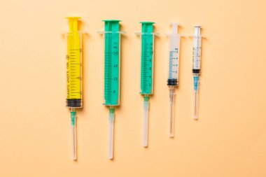 Turuncu arka planda farklı şırıngaların üst görüntüsü. Kopya alanı ile tıbbi enjeksiyon kavramı.