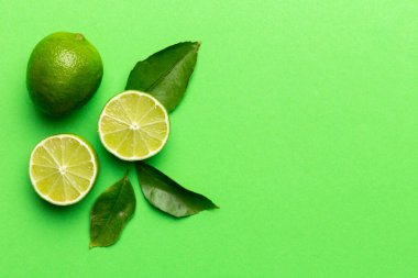 Yeşil yapraklı kireç meyveleri ve beyaz arka planda yarım dilim kesilmiş. Üst Manzara. Kopyalama alanı olan düz.