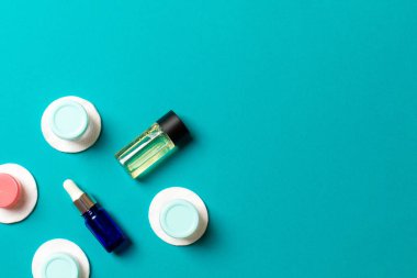 Renkli arka planda seyahat boyutunda kozmetik şişeler. Krema kavanozları düzdü. Vücut bakım stili kavramının en üst görünümü.