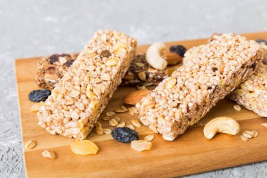 Arka planda çeşitli granola barlar var. Mısır gevreği gofretleri. Yulaf, fındık ve böğürtlenli kahvaltı barları, yakın çekim. Süper yiyecek konsepti.