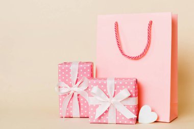 Shopping bag with gift box on colored background perspecrive view. Space for text holiday concept.