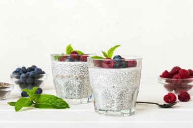 Sağlıklı kahvaltı ya da sabah chia tohumlu vanilyalı puding ahududu ve böğürtlen, vejetaryen gıda, diyet ve sağlık konsepti. Ahududu ve yabanmersinli Chia pudingi..