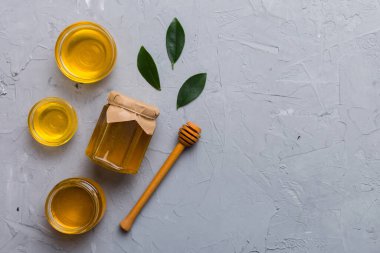 Bal kavanozu, beyaz arka plan manzaralı ve fotokopi alanı olan ahşap bal kaplama. Lezzetli bal şişesi.