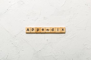 Apandisit kelimesi tahta bloğa yazılmış. Tablo üzerinde ek metin, konsept.