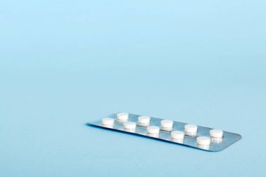 Arka planda aspirin olan kabarcık paketi. Arka planda ilaç hapları. İlaçlar ve reçeteli haplar arka plandaydı. beyaz tıbbi haplar su topladı..