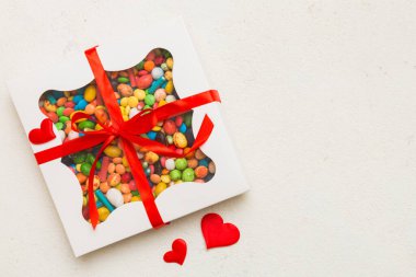 Valentine day composition: sweet candy, with gift boxes with bow and red felt hearts, photo template, background. Top View with copy space.