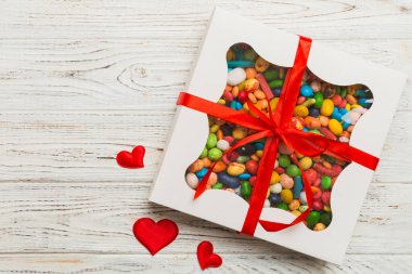 Valentine day composition: sweet candy, with gift boxes with bow and red felt hearts, photo template, background. Top View with copy space.