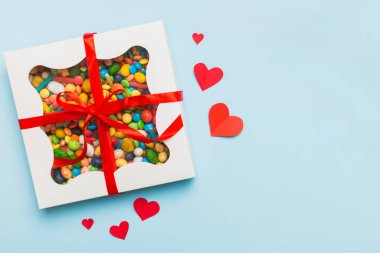 Valentine day composition: sweet candy, with gift boxes with bow and red felt hearts, photo template, background. Top View with copy space.