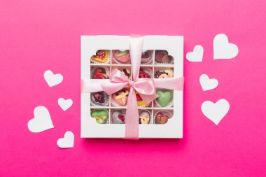 Valentine day composition: sweet candy, with gift boxes with bow and red felt hearts, photo template, background. Top View with copy space.