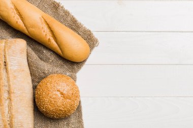 Kırsal masa manzaralı peçeteli taze pişmiş ekmek çeşitleri. Sağlıklı mayasız ekmek. Fransız ekmeği.