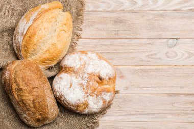 Kırsal masa manzaralı peçeteli taze pişmiş ekmek çeşitleri. Sağlıklı mayasız ekmek. Fransız ekmeği.