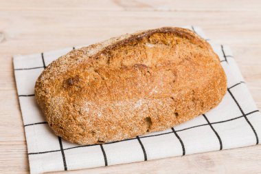 Kırsal masa manzaralı peçeteli taze pişmiş ekmek. Sağlıklı beyaz ekmek izole edilmiş..