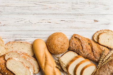Ev yapımı doğal ekmek. Arka plan olarak farklı taze ekmek türleri, kopya alanı ile üst görünüm.