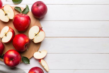 Yeşil yapraklı taze kırmızı elmalar. Bıçakla kesme tahtası. Üst görünüm.