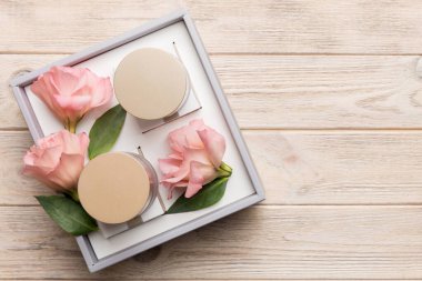 Ahşap zemin üzerinde yeşil yapraklar olan organik kozmetik ürünler. Uzayı kopyala, düz yat.