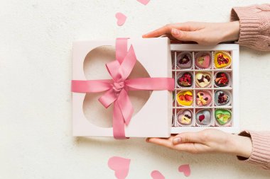 Renkli kutuda lezzetli şekerlemeleri olan kadın elleri.