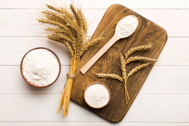 Tahta kasede buğday unu ve renkli arka planda buğday dikenleri. dünya buğday krizi.