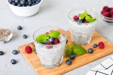 Sağlıklı kahvaltı ya da sabah chia tohumlu vanilyalı puding ahududu ve böğürtlen, vejetaryen gıda, diyet ve sağlık konsepti. Ahududu ve yabanmersinli Chia pudingi..