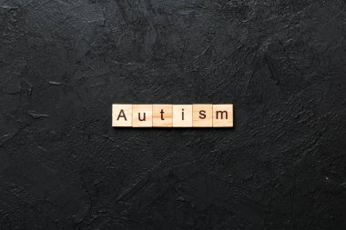 autism word written on wood block. autism text on table, concept. clipart