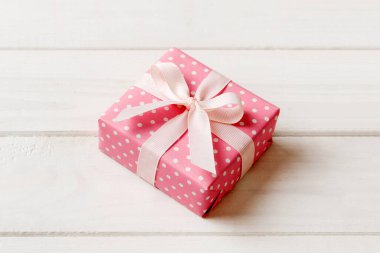 Noel 'i ya da diğer tatil hediyelerini renkli arka planda kurdeleyle renkli kağıda sardım. Şimdiki kutu, renkli tabloda hediye süslemesi, kopya alanı ile üst görünüm.