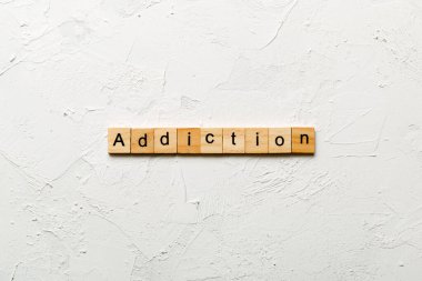 Tahta blokta yazan bağımlılık kelimesi. Masada bağımlılık metni, konsept.