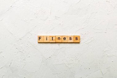 Tahta blokta fitness kelimesi yazıyor. Masada fitness metni, konsept.