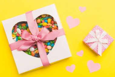 Valentine day composition: sweet candy, with gift boxes with bow and red felt hearts, photo template, background. Top View with copy space.