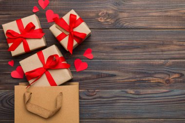 Gift boxes pop out from paper bag top view on colored background. bag packing handmade boxes fall out Concept of holidays, shopping, sale, discounts. Top view, flat lay.