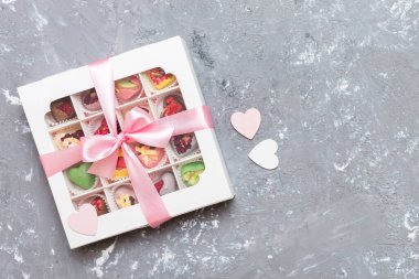Valentine day composition: sweet candy, with gift boxes with bow and red felt hearts, photo template, background. Top View with copy space.