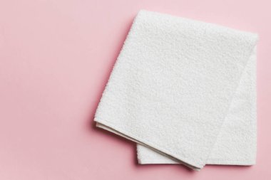 Renkli arkaplanda kopyalama alanı olan beyaz havluların üst görünümü.