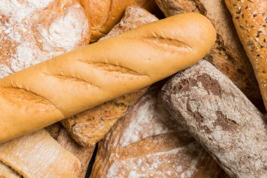 Ev yapımı doğal ekmek. Arka plan olarak farklı taze ekmek türleri, kopya alanı ile üst görünüm.