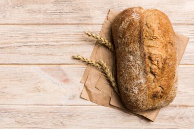 Taze ev yapımı tam buğday ekmeği. Peçetedeki ekmek kırsal arka planda, taze ekmek üst görünümü.