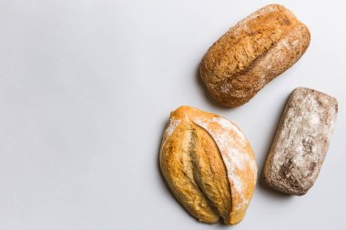 Ev yapımı doğal ekmek. Arka plan olarak farklı taze ekmek türleri, kopya alanı ile üst görünüm.