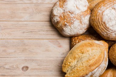 Ev yapımı doğal ekmek. Arka plan olarak farklı taze ekmek türleri, kopya alanı ile üst görünüm.