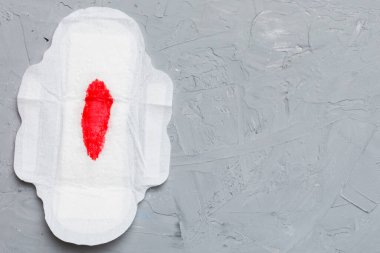 Kadın hijyen ürünleri ya da arka planda kırmızı tüy olan hijyenik ped. Pastel renk. - Yakın çekim. Mesaj için boş bir yer. Kadın günlük hijyeni..