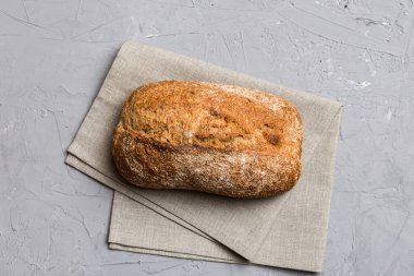 Taze ev yapımı tam buğday ekmeği. Peçetedeki ekmek kırsal arka planda, taze ekmek üst görünümü.