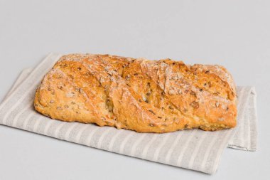 Kırsal masa manzaralı peçeteli taze pişmiş ekmek. Sağlıklı beyaz ekmek izole edilmiş..