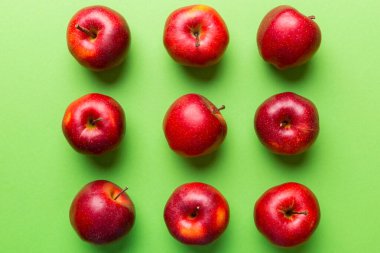 Renkli arka planda bir sürü kırmızı elma, üst manzara. Görüş üzerinde taze elma ile sonbahar deseni.