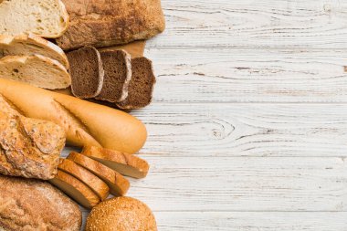 Ev yapımı doğal ekmek. Arka plan olarak farklı taze ekmek türleri, kopya alanı ile üst görünüm.