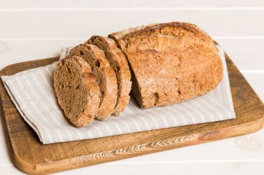 Köy manzaralı peçeteli taze dilimlenmiş ekmek çeşitleri. Sağlıklı mayasız ekmek. Fransız ekmeği dilimi.