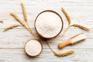 Tahta kasede buğday unu ve renkli arka planda buğday dikenleri. dünya buğday krizi.