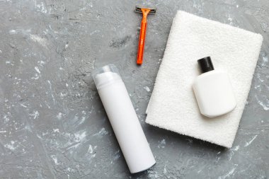 Tıraş Adam seti. Traş makinesi, havlu, losyon ve renkli arka planda tıraş köpüğü. Erkekler banyo aksesuarları üst görünüm.