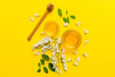 Akasya çiçekli ve yapraklı bal kavanozu. Taze bal üst görünüm düz yatıyordu.