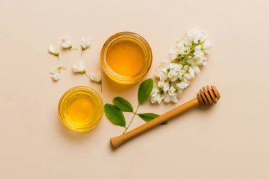 Akasya çiçekli ve yapraklı bal kavanozu. Taze bal üst görünüm düz yatıyordu.