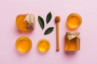 Bal kavanozu, beyaz arka plan manzaralı ve fotokopi alanı olan ahşap bal kaplama. Lezzetli bal şişesi.