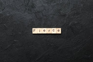 Fierce word written on wood block. Fierce text on cement table for your desing, Top view concept. clipart