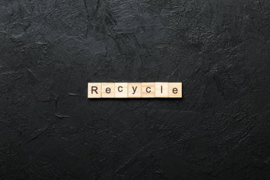 Tahta blokta yazan geri dönüşüm kelimesi. Geri dönüşüm metni desing, konsept için çimento tablo üzerinde.